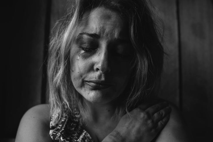 grayscale photo of woman crying holding her right chest Photo by Kat J on Unsplash